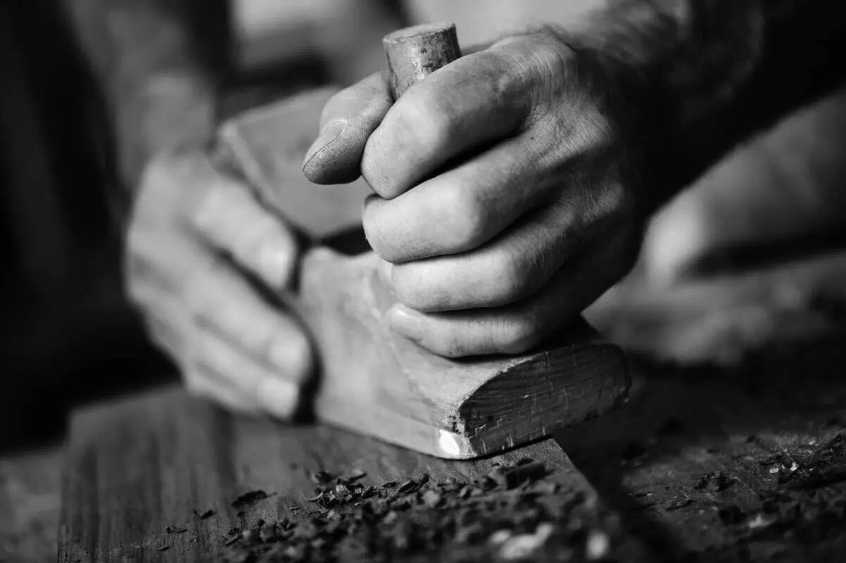 craftsman's hands planing wood